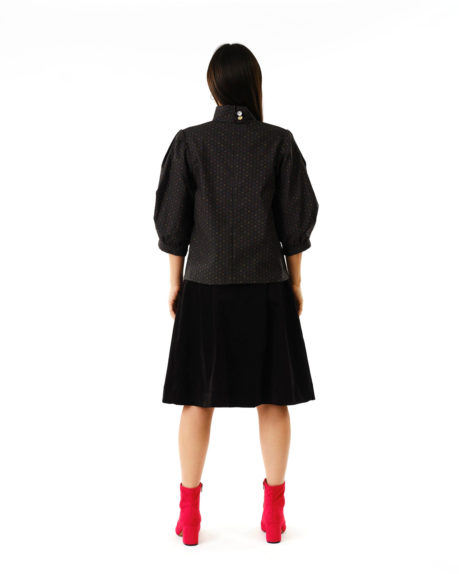 Jennifer Glasgow Design polka dot puff sleeve blouse back view with black skirt and pink ankle boots in Kelowna
