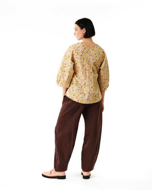 Jennifer Glasgow Design model wearing floral yellow puff sleeve blouse with relaxed fit and brown pants in Kelowna