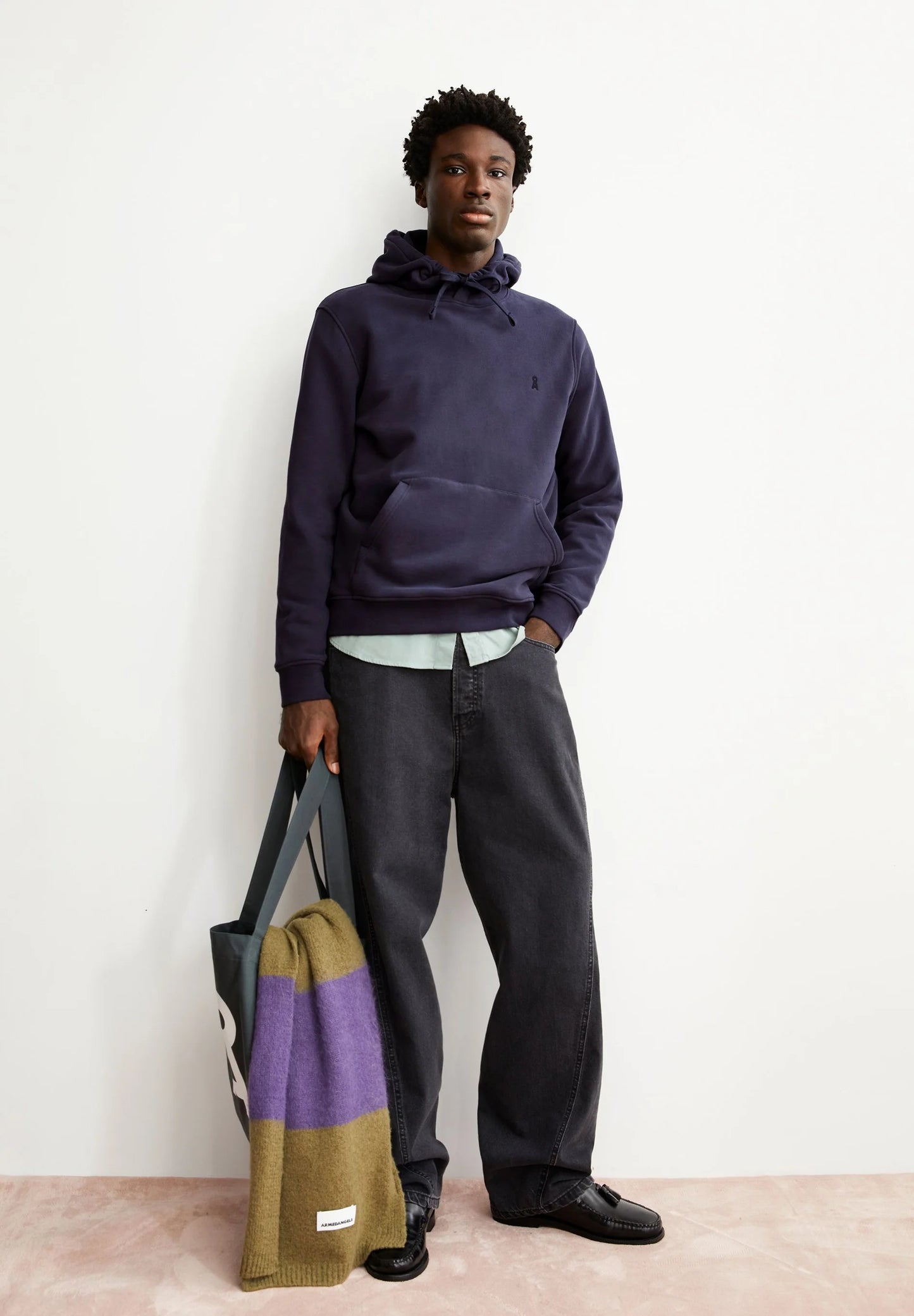 Men's ARMEDANGELS  Canada  Hoodie Paired with Dark Jeans and a Colorful Tote Bag
