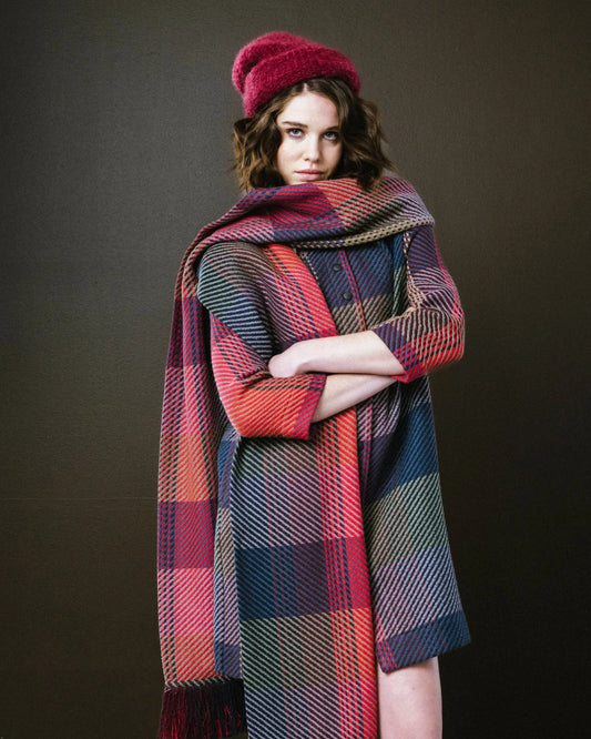 Model wearing a colorful plaid scarf from BodyBag by Jude, styled with a matching hat